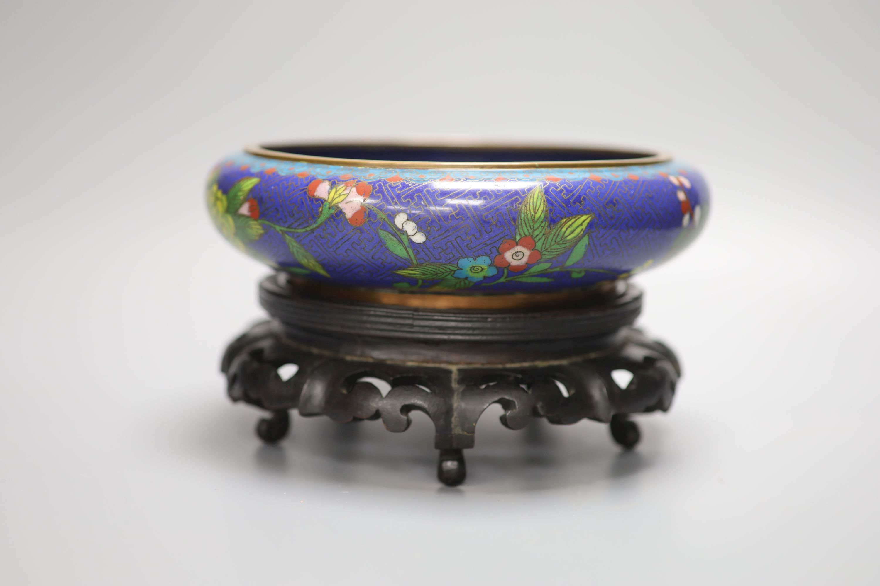 A pair of early 20th century Chinese cloisonne enamel jars and covers and a similar bowl and wood stand, tallest 20cm